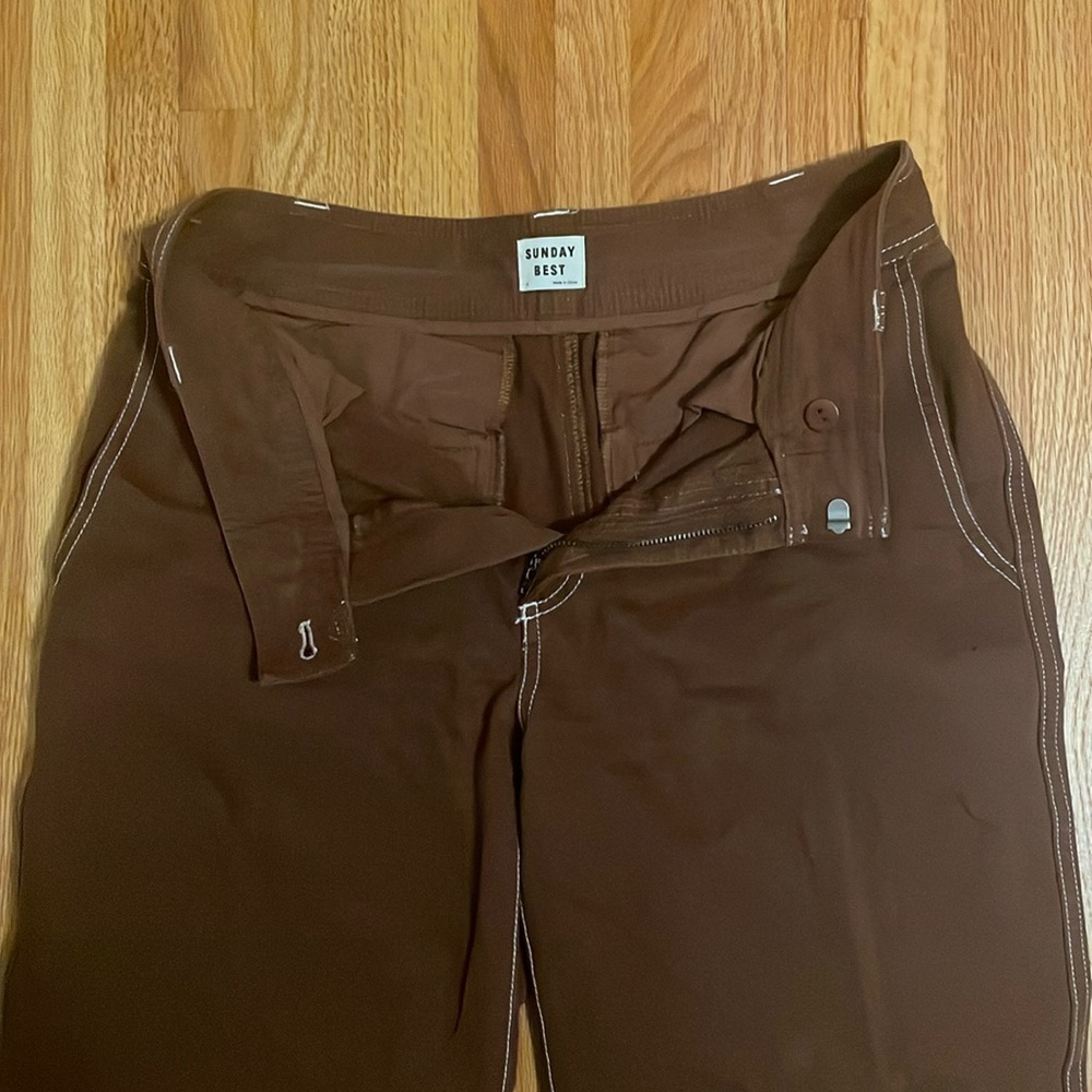 Chocolate, brown, wide, leg denim with white stitching.